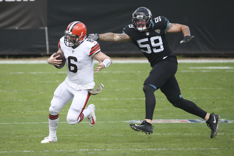 Cleveland Browns quarterback Baker Mayfield (6) tries to avoid a sack by Jacksonville Jaguars defensive end Aaron Lynch (59) during the first half of an NFL football game, Sunday, Nov. 29, 2020, in Jacksonville, Fla. (AP Photo/Stephen B. Morton)