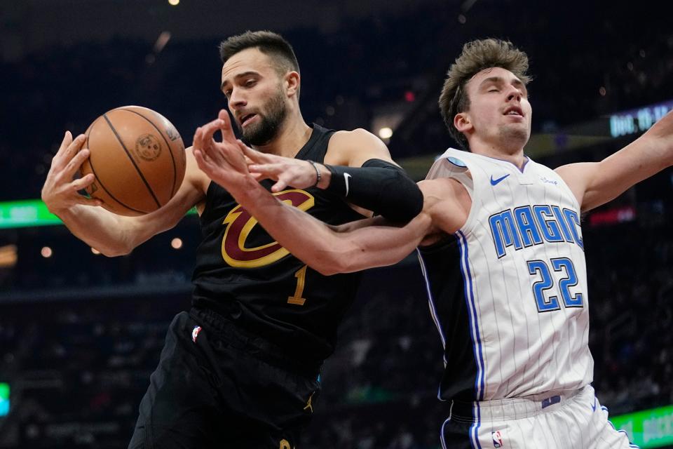 Cleveland Cavaliers guard Max Strus (1) grabs a rebound next to Orlando Magic forward Franz Wagner (22) during the first half of an NBA basketball game Wednesday, Dec. 6, 2023, in Cleveland. (AP Photo/Sue Ogrocki)