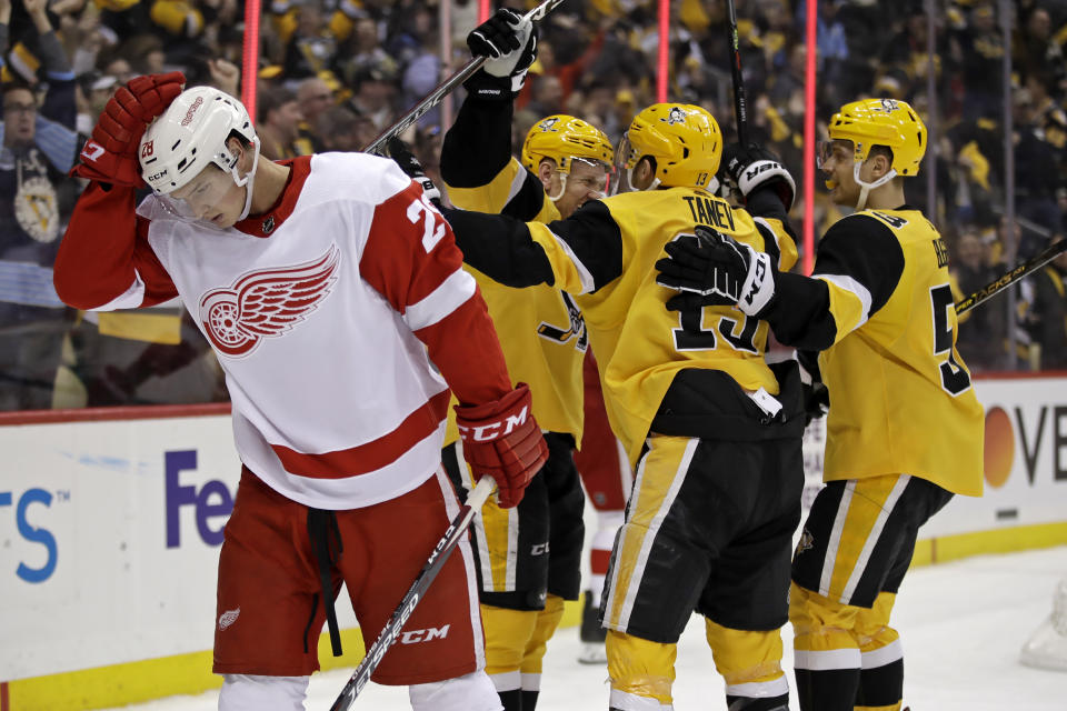 CORRECTS TO SECOND GOAL NOT THIRD GOAL AS A SCORING CHANGE TOOK AWAY HORNQVIST’S FIRST-PERIOD GOAL AND THAT SCORE WAS LATER CREDITED TO SAM LAFFERTY - Pittsburgh Penguins' Patric Hornqvist, center rear, celebrates his second goal of the team's NHL hockey game as Detroit Red Wings' Gustav Lindstrom (28) skates back to his bench during the second period in Pittsburgh, Sunday, Feb. 16, 2020. (AP Photo/Gene J. Puskar)