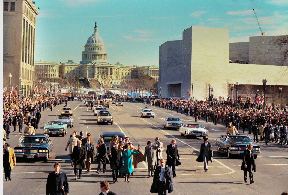 U.S. President Jimmy Carter, center left, and first lady Rosalynn Carter hold hands as they walk down Pennsylvania Avenue during the inaugural parade in Washington, D.C., Jan. 20, 1977. (AP Photo)