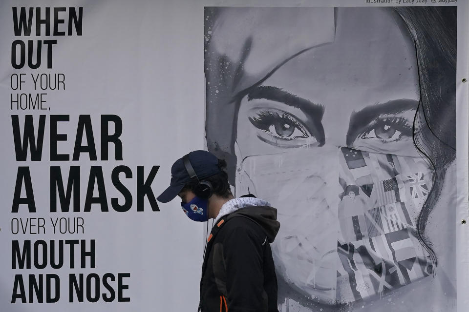 Afiche que recomienda el uso de tapabocas cuando se sale de la casa en un muro de San Francisco, fotografiado el 21 de noviembre del 2020. (AP Photo/Jeff Chiu, File)