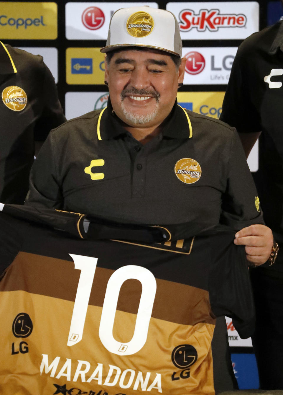 Former soccer great Diego Maradona, shows his team jersey during a press conference where he was presented as the new manager of the Dorados of Sinaloa, in Culiacan, Mexico, Monday, Sept. 10, 2018. Maradona, whose public battles with cocaine made him soccer's poster child for the perils of substance abuse, is setting up camp in Mexico's drug cartel heartland as the new coach of a second-tier team. (AP Photo/Marco Ugarte)