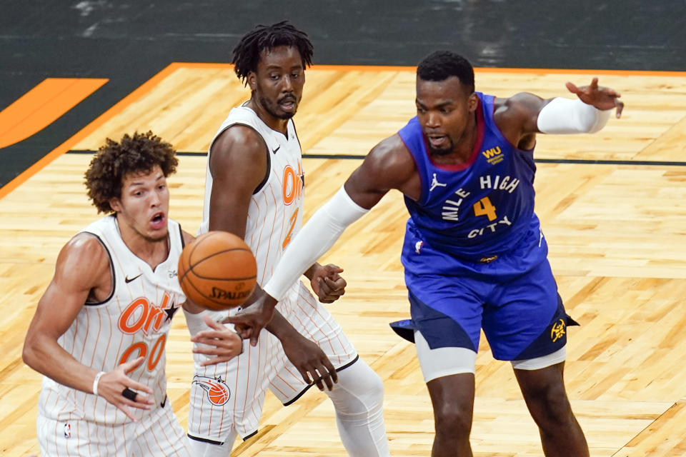 Orlando Magic forward Aaron Gordon (00) and forward Al-Farouq Aminu, center, go after a loose ball against Denver Nuggets forward Paul Millsap (4) during the second half of an NBA basketball game, Tuesday, March 23, 2021, in Orlando, Fla. (AP Photo/John Raoux)