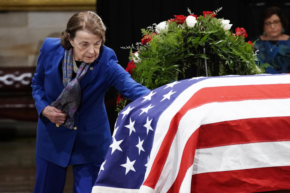 FILE - Sen. Dianne Feinstein, D-Calif., touches the flag-draped casket of former Sen. Bob Dole, of Kansas, as he lies in state in the Rotunda of the U.S. Capitol in Washington, Thursday, Dec. 9, 2021. (Ken Cedeno/Pool Photo via AP, File)