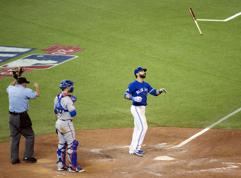 El jugador de los Azulejos, José Bautista, derecha, tira su bate tras conectar un jonrón conra los Rangers de Texas el 14 de octubre de 2015 en Toronto. (Darren Calabrese/The Canadian Press via AP, File) MANDATORY CREDIT