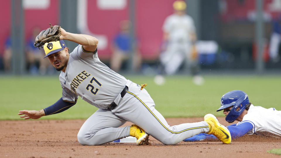 Milwaukee Brewers shortstop Willy Adames (27) catches a bad throw as Kansas City Royals' Bobby Witt Jr., right, steals second base during the first inning of a baseball game in Kansas City, Mo., Monday, May 6, 2024. (AP Photo/Colin E. Braley)