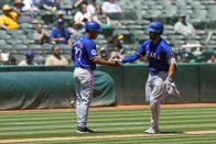 Texas Rangers' Marcus Semien, right, celebrates with third base coach Tony Beasley after hitting a solo home run against the Oakland Athletics during the third inning in the first baseball game of a doubleheader Wednesday, May 8, 2024, in Oakland, Calif. (AP Photo/Godofredo A. Vásquez)