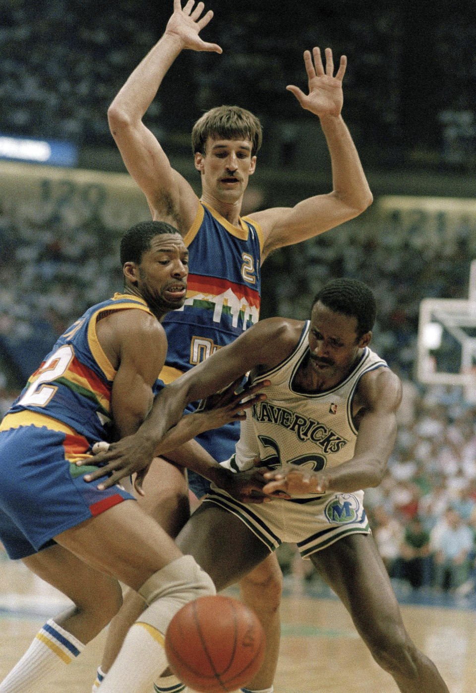 FILE - Denver Nuggets guard Lafayette Lever (12) and forward Bill Henzlik (24) prevent Dallas Mavericks guard Rolando Blackman (22) from going for the basket during an NBA basketball game in Dallas, May 14, 1988. Now, with the Nuggets the top-seed in the Western Conference, Denver has never seemed to be mistaken for much beyond an NBA novelty. And if there really is gold at the end of all those rainbows, a real Nuggets fan will have to see it to believe it. (AP Photo/Pat Sullivan, File)