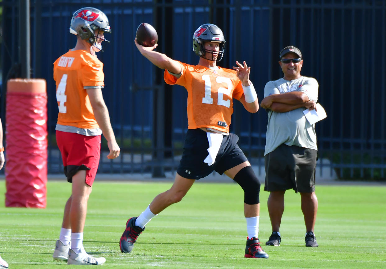 Ryan Griffin #4 (L) and quarterback coach Clyde Christensen (R) look on as Tom Brady #12 of the Tampa Bay Buccaneers throws a pass during the Buccaneers Mini-Camp at AdventHealth Training Center on June 08, 2021 in Tampa, Florida. (Photo by Julio Aguilar/Getty Images)