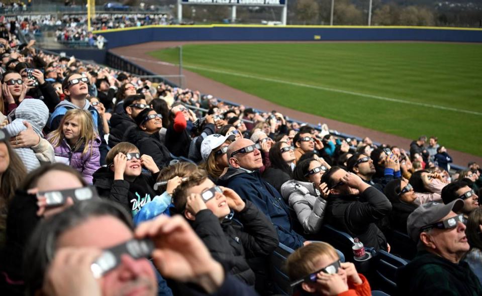 People look at up the sky to see a glimpse of the solar eclipse through the clouds during SolarFest on Monday at Medlar Field. SolarFest, hosted by Penn State’s Eberly College of Science and the State College Spikes, drew over 8,000 people. Abby Drey/adrey@centredaily.com