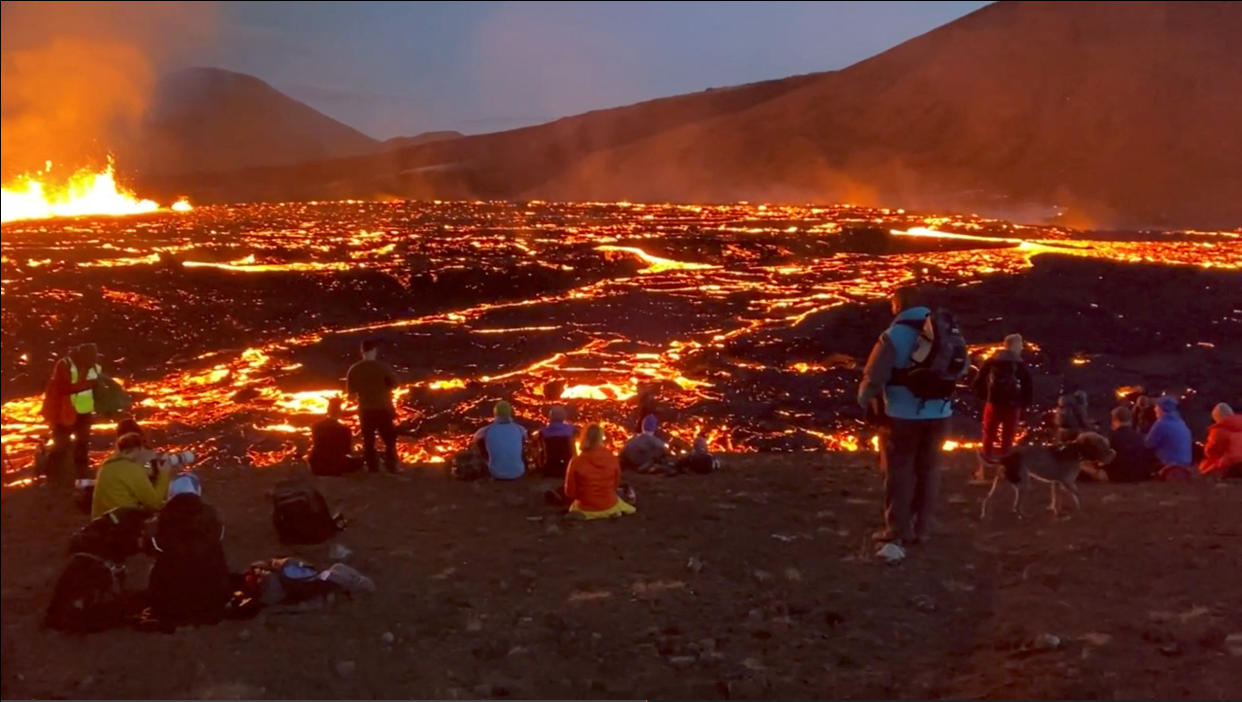 People look on as Fagradalsfjall volcano erupts near Reykjavik, Iceland, August 3, 2022 in this screen grab obtained from a social media video. Instagram/@alberttourguideiceland/via REUTERS  THIS IMAGE HAS BEEN SUPPLIED BY A THIRD PARTY. MANDATORY CREDIT.