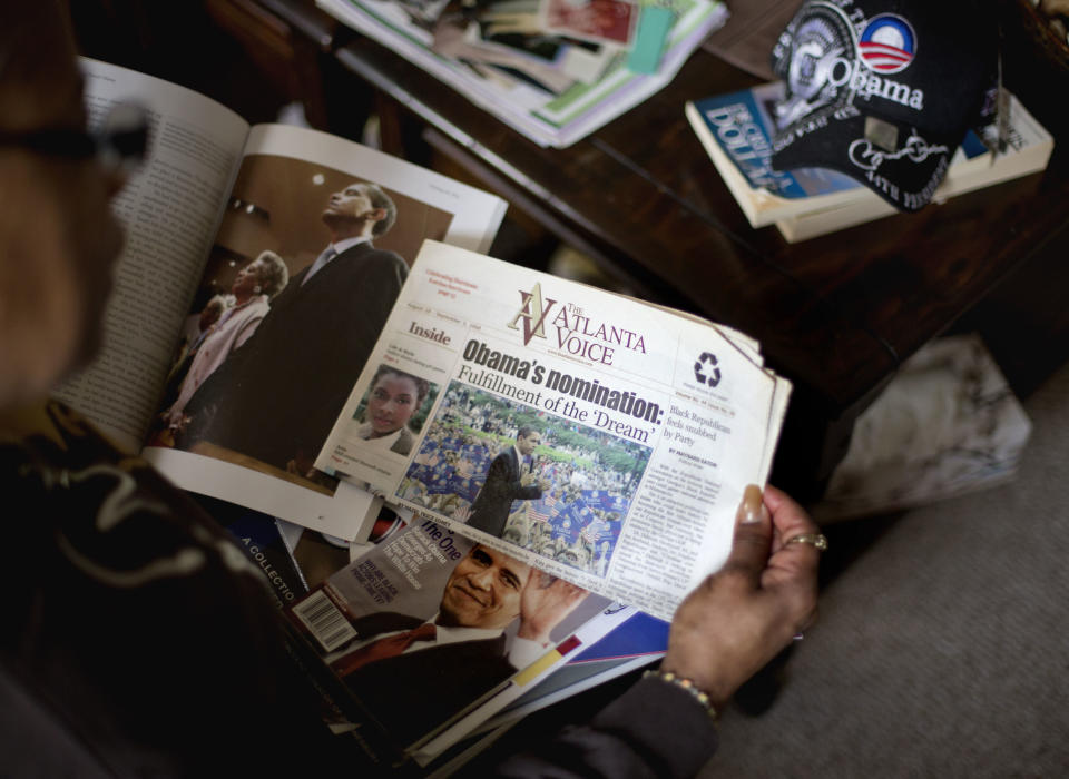 This Jan. 2, 2013, photo, shows Victoria Wimberley, who will be attending President Barack Obama's inauguration for the second time, looking over some of the memorabilia in her home in Decatur, Ga. Four years and one re-election after his historic oath-taking as America's first black president, some of the thrill for Barack Obama is gone. Wimberley brought four busloads of people to Washington for the 2009 inauguration. She's coming again this month, though with two fewer buses, which she blamed on the high price for accommodations, not any lack of excitement for Obama. (AP Photo/David Goldman)