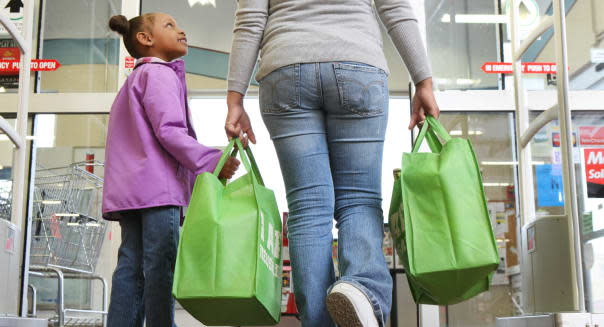 Mom and daughter walking out of grocery store.