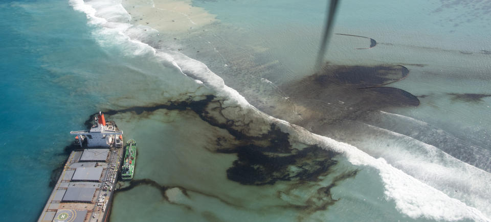 This photo provided by the French Army shows oil leaking from the MV Wakashio, a bulk carrier ship that ran aground off the southeast coast of Mauritius, Tuesday Aug.11, 2020. Thousands of students, environmental activists and residents of Mauritius were working around the clock trying to reduce the damage to the Indian Ocean island from an oil spill after a tanker ran aground on a coral reef. An estimated 1 ton of oil from the Japanese ship's cargo of 4 tons has already escaped into the sea, officials said. (Gwendoline Defente, EMAE via AP)