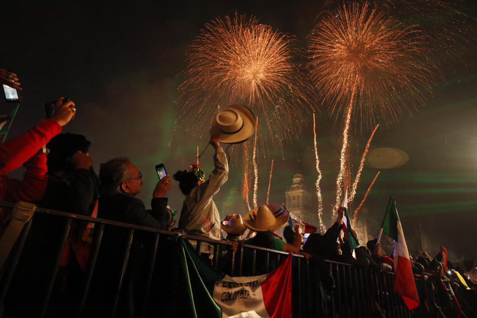 Revelers celebrate as fireworks explode over the Metropolitan Cathedral after President Andres Manuel Lopez Obrador gave the annual independence shout from the balcony of the National Palace to kick off Independence Day celebrations in Mexico City, late Sunday, Sept. 15, 2019. Every year the Mexican president marks the "Grito de Dolores," commemorating the 1810 call to arms by priest Miguel Hidalgo that began the struggle for independence from Spain, achieved in 1821. (AP Photo/Rebecca Blackwell)