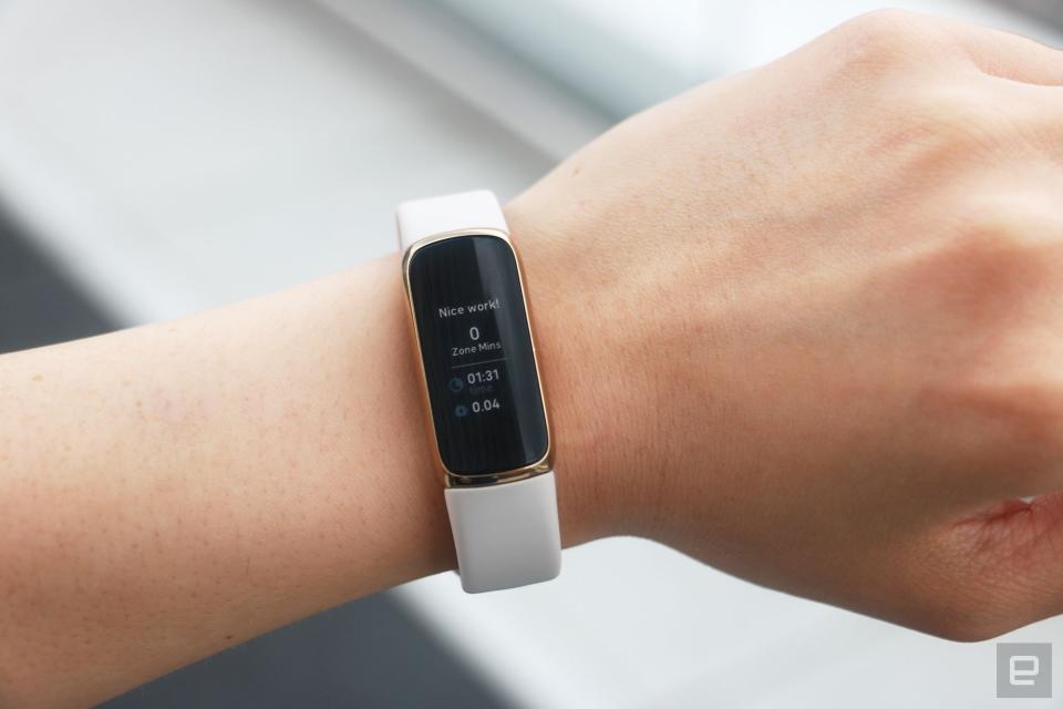 <p>The Fitbit Luxe with a light pink silicone band on a wrist facing the camera. The screen shows a post workout report saying "Nice work!" with results including 0 zone minutes earned and 1 minute and 31 seconds spent covering 0.04 miles.</p>
