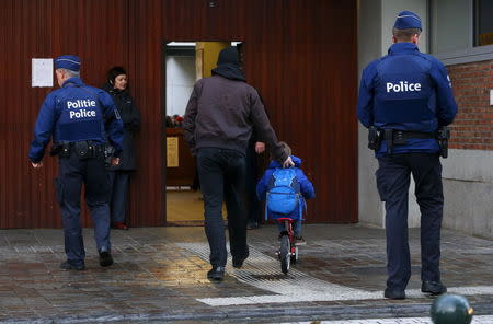 Belgian police officers stand guard outside a school in central Brussels November 25, 2015. REUTERS/Yves Herman