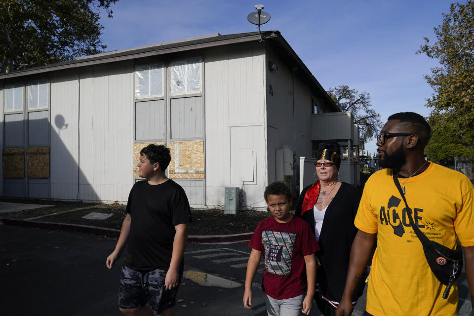 Kim Carlson, third from left, her two grandsons and community organizer Devin Williams, right, walk around the Delta Pines apartment complex, Friday, Nov. 4, 2022, in Antioch, Calif. Despite a landmark renter protection law approved by California legislators in 2019, tenants across the country’s most populous state are taking to ballot boxes and city councils to demand even more safeguards. They want to crack down on tenant harassment, shoddy living conditions and unresponsive landlords that are usually faceless corporations. (AP Photo/Godofredo A. Vásquez)