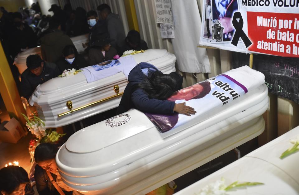 A woman cries over a coffin containing the remains of her friend Antonio Samillan who died during the unrest in Juliaca, Peru, Tuesday, Jan. 10, 2023. At least 17 people died Monday in southeast Peru as protests seeking immediate elections resumed in neglected rural areas of the country still loyal to ousted President Pedro Castillo. (AP Photo/Jose Sotomayor)