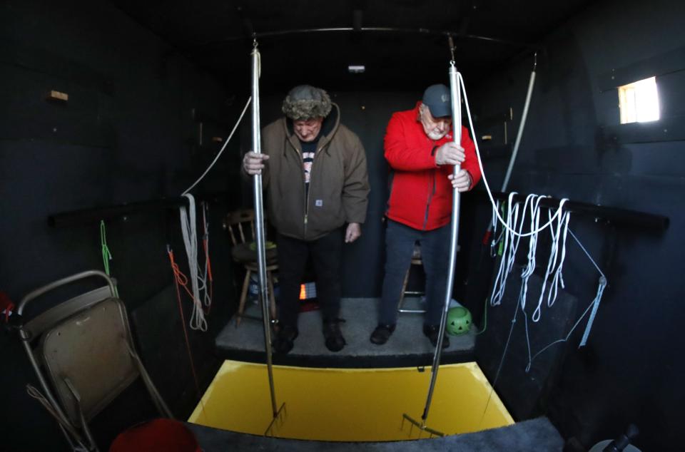 Brothers Roy Dietzen from Darboy, left, and Paul Dietzen man their spears during the first day of sturgeon spearing season Feb.11, 2023, on Lake Poygan in Larsen