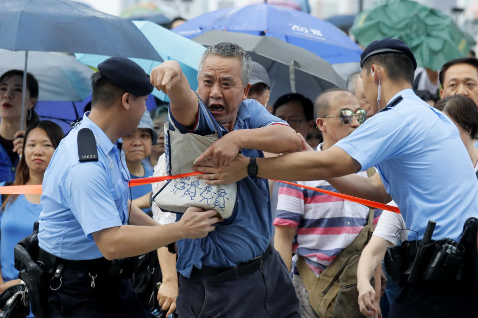 A pro-China's supporter shouts at pro-democracy protesters during a rally outside Legislative Council Complex in Hong Kong, Sunday, June 30, 2019. Pro-China's supporters rallied in support of the police at Tamar Park (AP Photo/Kin Cheung)