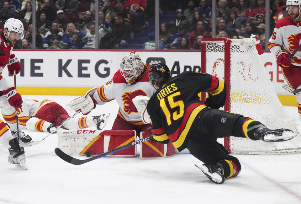 Calgary Flames goalie Jacob Markstrom stops Vancouver Canucks' Sheldon Dries (15) during the second period of an NHL hockey game Saturday, April 8, 2023, in Vancouver, British Columbia. (Darryl Dyck/The Canadian Press via AP)