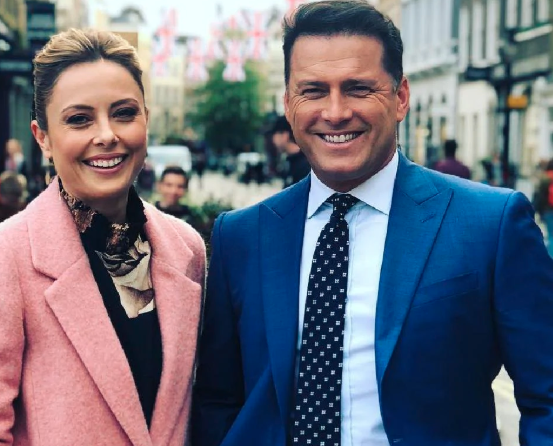 Karl Stefanovic and Allison Langdon pose for the camera with Karl in a suit and Allison in a pink coat