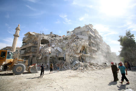 People inspect a damaged site after an air strike Sunday in the rebel-held besieged al-Qaterji neighbourhood of Aleppo, Syria October 17, 2016. REUTERS/Abdalrhman Ismail