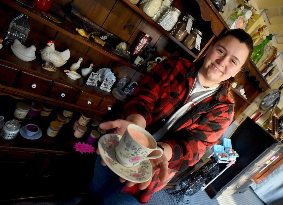 Ashley Drew shows one of her homemade teacup candles on display at the Glaeser Family Farm in Dundee.