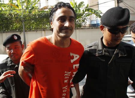 Police officers escort Gurmeet Singh, also known as Jagtar Singh Tara, from India, as they arrive at the criminal court in Bangkok January 6, 2015. REUTERS/Chaiwat Subprasom