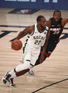 August 6, 2020; Lake Buena Vista, Florida, USA; Milwaukee Bucks forward Khris Middleton (22) moves the ball against Miami Heat guard Andre Iguodala (28) during the second half of an NBA basketball game Thursday, Aug. 6, 2020, in Lake Buena Vista, Fla. (Kim Klement/Pool Photo via AP)