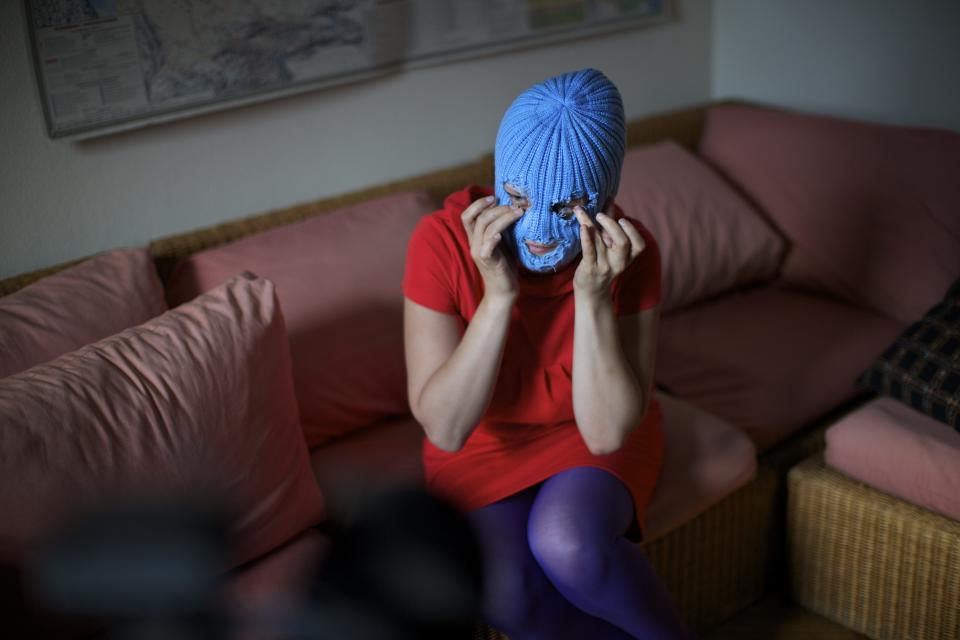 A member of Russian punk band Pussy Riot, who gave only her stage name of Grelka, wears a blue balaclava as speaks to the media in Moscow, Tuesday, July 16, 2013. Russian provocateurs Pussy Riot are back in action, releasing their first music video since three members went to prison last year for a prank denouncing Vladimir Putin. The video shows band members in trademark bright-colored balaclavas and short skirts, cavorting and shrieking atop an oil rig. Backed by hectic guitar and a drum fusillade, they pour oil on a large photo of state oil giant Rosneft’s chairman and liken Putin to an Iranian ayatollah. Pussy Riot member Grelka said after the video’s Tuesday release that “the main message is that Putin has spread the country’s wealth among his friends.” (AP Photo/Alexander Zemlianichenko)