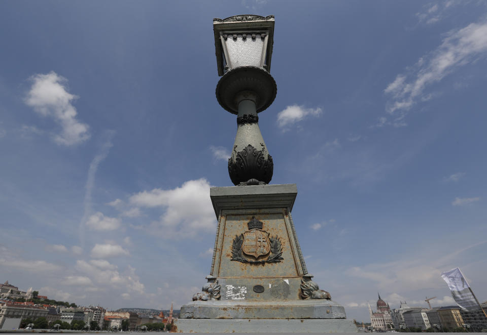 In this photo taken on Wednesday, June 5, 2019, a lamp on the Chain Bridge over the Danube River in Budapest. A tourism boom in the Hungarian capital has led to major congestion on the river flowing through the city, with sightseeing boats and floating hotels competing for better positions in front of spectacular neo-Gothic buildings, ornate bridges and churches lining the Danube. (AP Photo/Laszlo Balogh)
