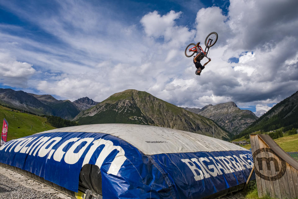 A downhill cyclist practices a difficult jump with the safety of landing on a big airbag in the Mottolino Bike Park. (Photo by Frank Bienewald/LightRocket via Getty Images)