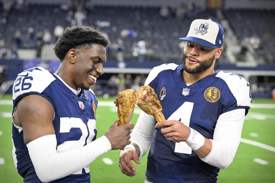 Nov 23, 2023; Arlington, Texas, USA; Dallas Cowboys cornerback DaRon Bland (26) and quarterback <a class="link " href="https://sports.yahoo.com/nfl/players/29369" data-i13n="sec:content-canvas;subsec:anchor_text;elm:context_link" data-ylk="slk:Dak Prescott;sec:content-canvas;subsec:anchor_text;elm:context_link;itc:0">Dak Prescott</a> (4) eat turkey legs after the Cowboys victory over the Washington Commanders at AT&T Stadium. Mandatory Credit: Jerome Miron-USA TODAY Sports