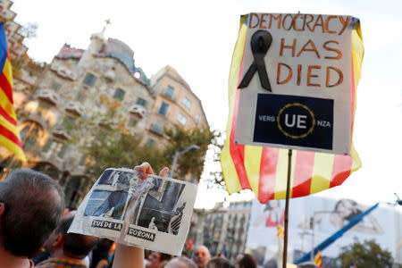 People wave placards and posters during a demonstration organised by Catalan pro-independence movements ANC (Catalan National Assembly) and Omnium Cutural, following the imprisonment of their two leaders Jordi Sanchez and Jordi Cuixart, in Barcelona, Spain October 21, 2017. REUTERS/Rafael Marchante