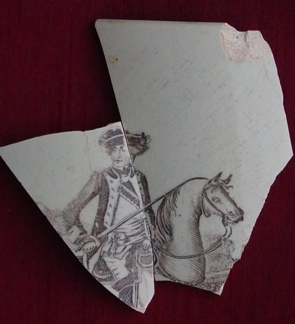 A fragment of brown printed pearlware, a type of ceramic ware, featuring George Washington on horseback (manufactured from 1790 to 1840), was found on the grounds of City Hall.