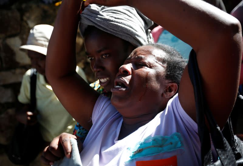 Women react after a fire destroyed part of an orphanage, in Port-au-Prince