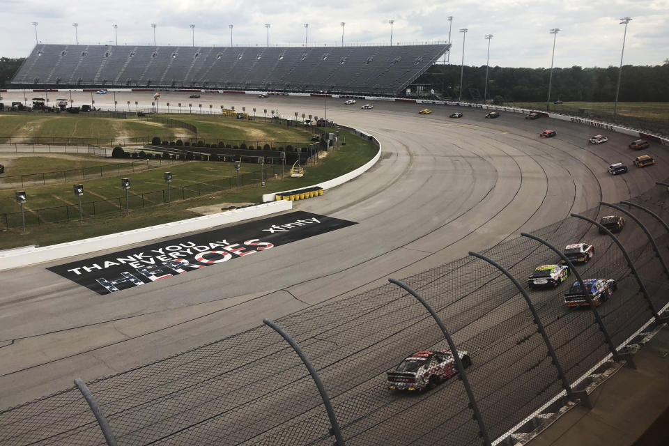 Cars go through a turn at Darlington Raceway during the NASCAR Cup Series auto race Sunday, May 17, 2020, in Darlington, S.C. (AP Photo/Jenna Fryer)