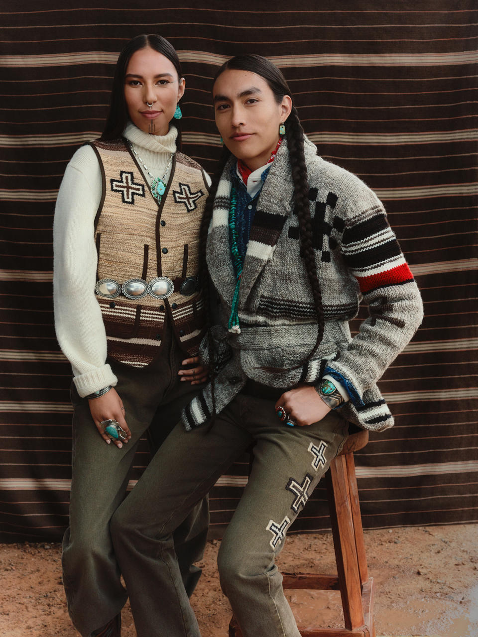 Quannah Chasinghorse stands next to Phillip Bread, who is sitting on a stool, as they model clothing from the Polo Ralph Lauren x Naiomi Glasses collection. 