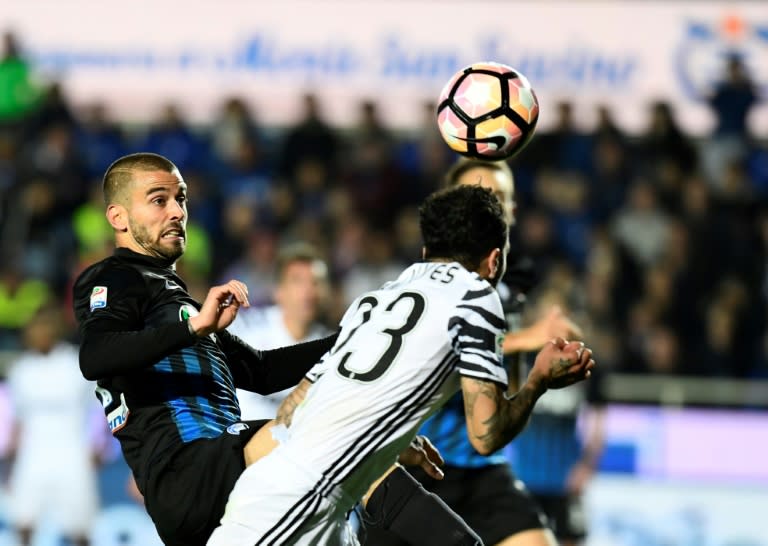 Juventus' Brazilian defender Daniel Alvez da Silva heads the ball and scores during their match against Atalanta