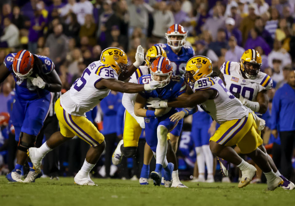 LSU defensive tackle Jordan Jefferson (99) and defensive end Sai'vion Jones (35) combine to tackle Florida quarterback Graham Mertz (15) during the second half of an NCAA college football game in Baton Rouge, La., Saturday, Nov. 11, 2023. (AP Photo/Derick Hingle)