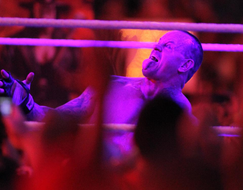 The Undertaker celebra en WrestleMania 28, luego de vencer a Triple H. (AP Images/Marc Serota)