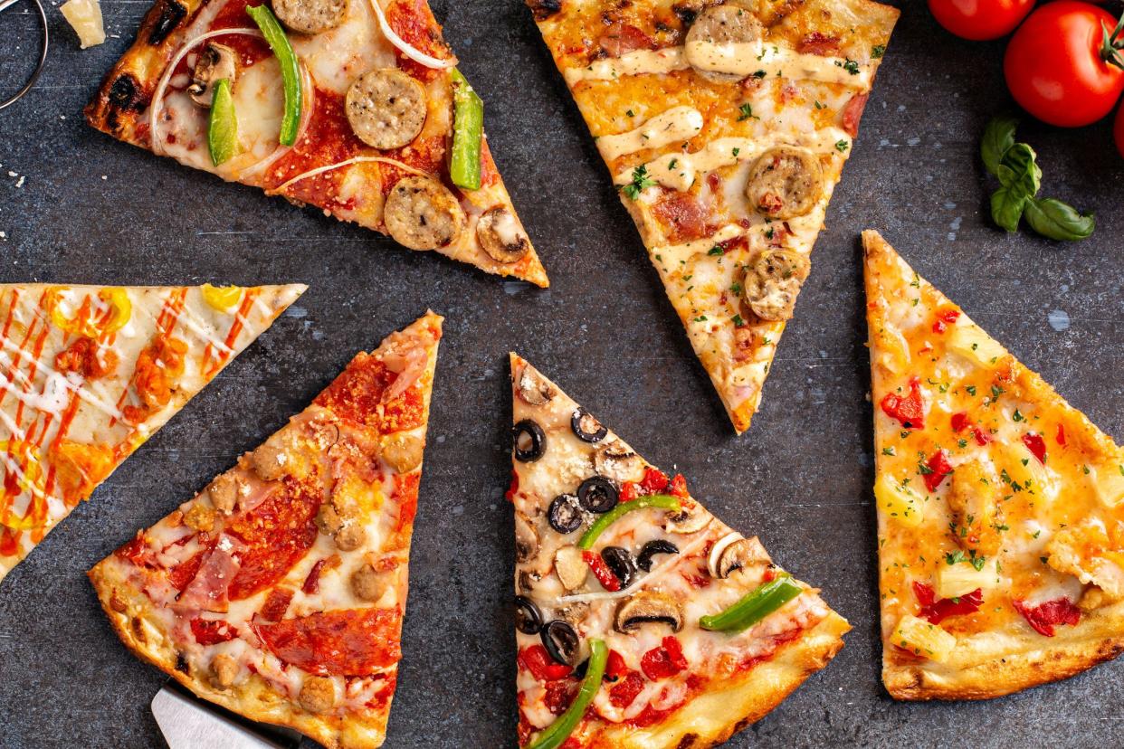 Variety of pizza slices with vegetarian, meat, hawaiian top view