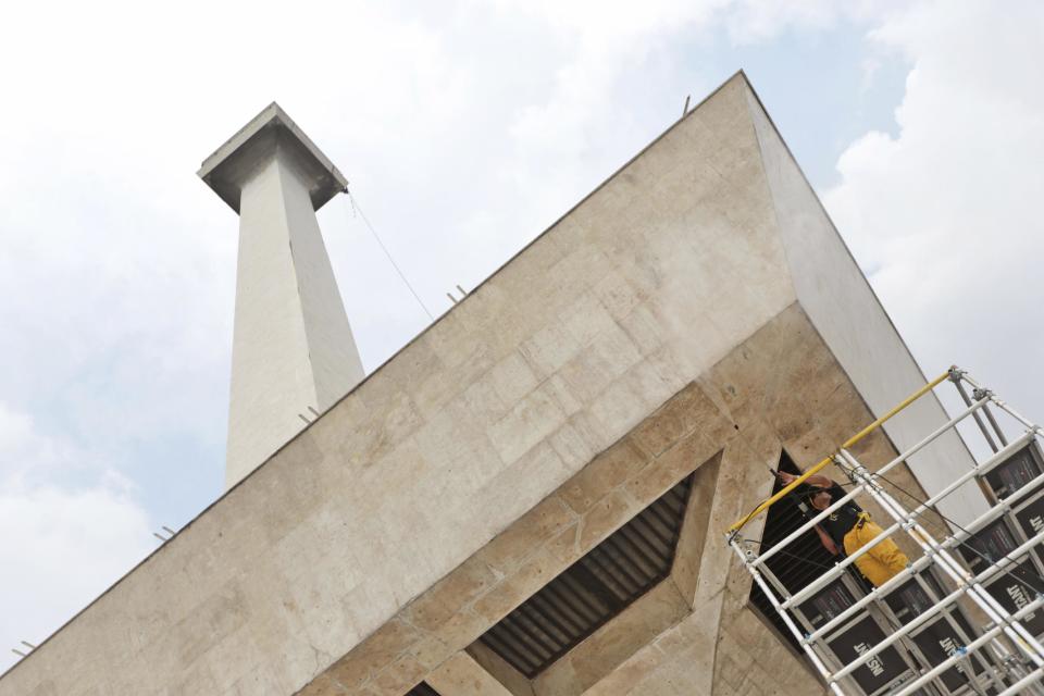 In this Thursday, May, 8, 2014 photo, a worker sprays water at the National Monument during its cleaning in Jakarta, Indonesia. The 132-meter (433-feet) tall monument, a popular landmark in the capital, is being cleaned for the first time in more than two decades. German-based Kaercher company, which specializes in the cleaning of cultural monuments, is doing the work. It also did the monument’s last cleaning in 1992. (AP Photo/Dita Alangkara)