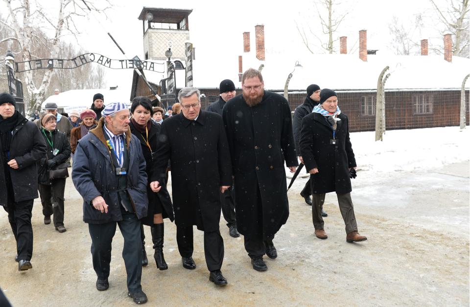 Polish President Bronislaw Komorowski (C), Piotr Cywinski (C-R), director of the Auschwitz-Birkenau museum and Auschwitz survivors arrive to lay down a wreath at the former Auschwitz concentration camp on January 27, 2015 at the camp's memorial site in Oswiecim, Poland. Seventy years after the liberation of Auschwitz, ageing survivors and dignitaries gather at the site synonymous with the Holocaust to honour victims and sound the alarm over a fresh wave of anti-Semitism.