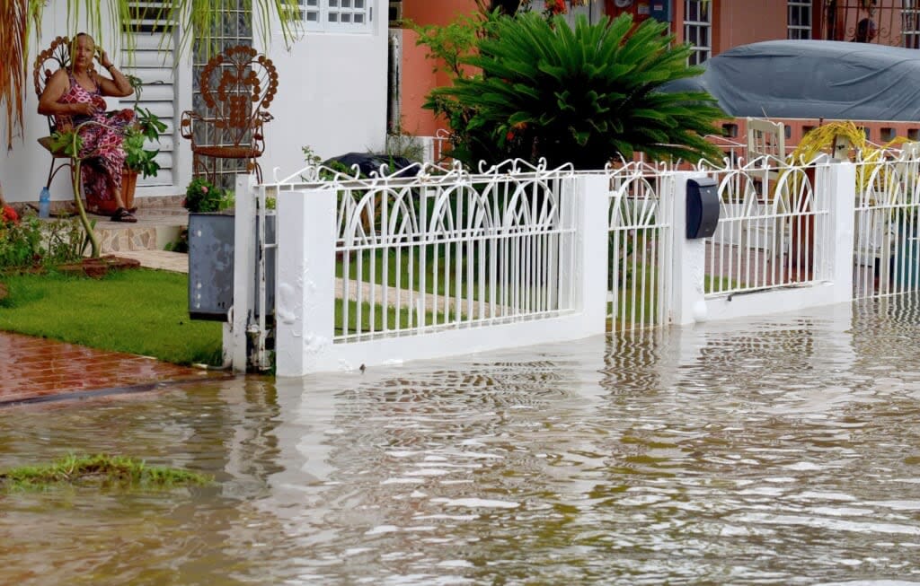 A woman watches a street flooded after the passage of hurricane Fiona in Salinas, Puerto Rico, on September 19, 2022. (Photo by JOSE RODRIGUEZ/AFP via Getty Images)