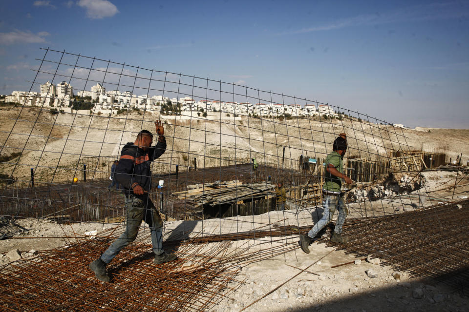 File -- In this Jan. 22, 2017 file photo, workers carry material at a construction site in the West Bank settlement of Maaleh Adumim. Yaakov Katz, a prominent West Bank settler, said Sunday, March 26, 2017, that the number of Israelis living in the West Bank has soared by nearly one quarter over the past five years to over 420,000 people. Katz says the rapid growth means the internationally backed idea of a two-state solution between Israel and the Palestinians is now impossible. (AP Photo/Mahmoud Illean, File)