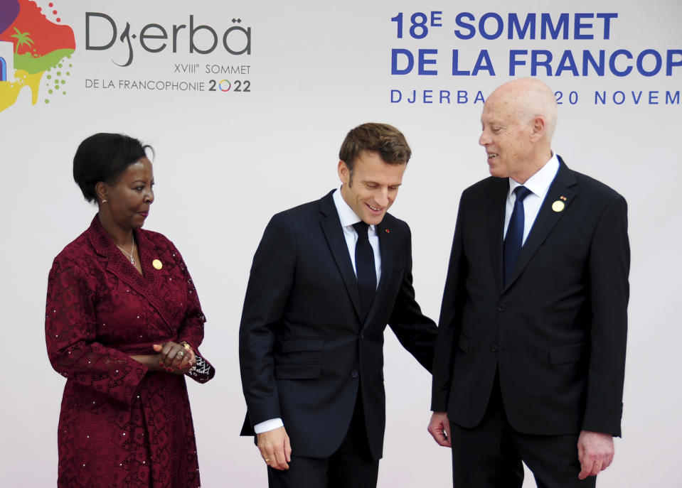 Tunisian President Kais Saied, right, and Louise Mushikiwabo, Secretary-General of the Organisation internationale de la Francophonie, left, receive French president Emmanuel Macron during the opening ceremony of the 18th Francophone Summit, in Djerba, Tunisia, Saturday, Nov. 19, 2022. (AP Photo/Hassene Dridi)