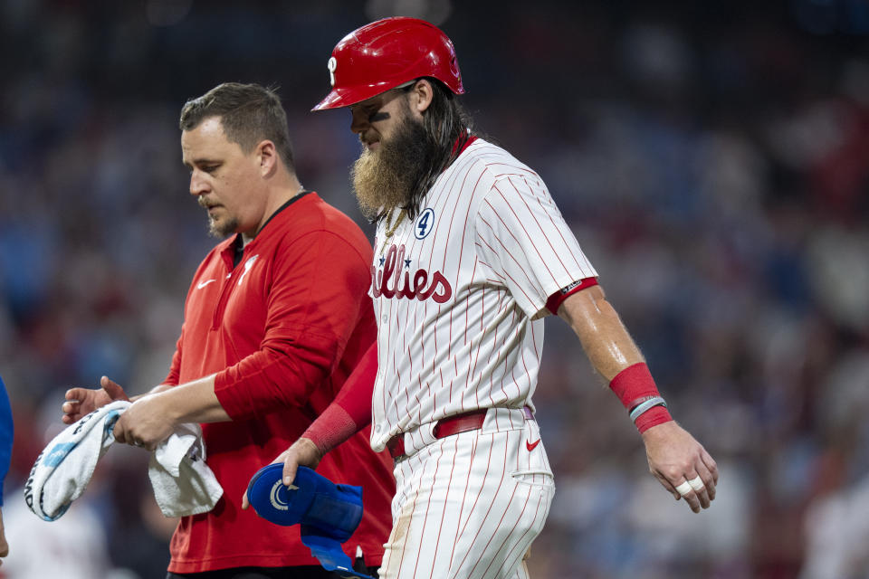 Philadelphia Phillies' Brandon Marsh, right, walks off with a member of the training staff after getting injuried during the eighth inning of a baseball game against the St Louis Cardinals, Sunday, June 2, 2024, in Philadelphia. (AP Photo/Chris Szagola)